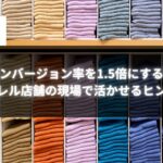 カラフルに畳まれたアパレル商品の棚と『コンバージョン率を1.5倍にする！アパレル店舗の現場で活かせるヒント集』というテキストが重なった画像。